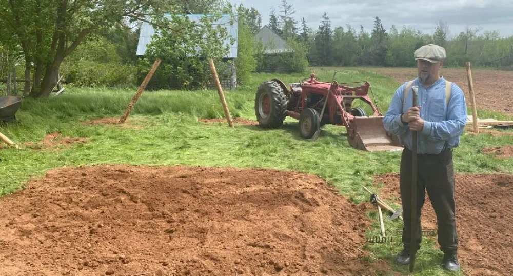 image of a person in a garden beside a field and tractor