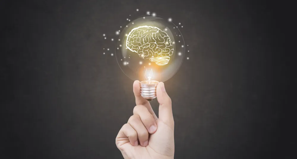 Hand holding glowing light bulb