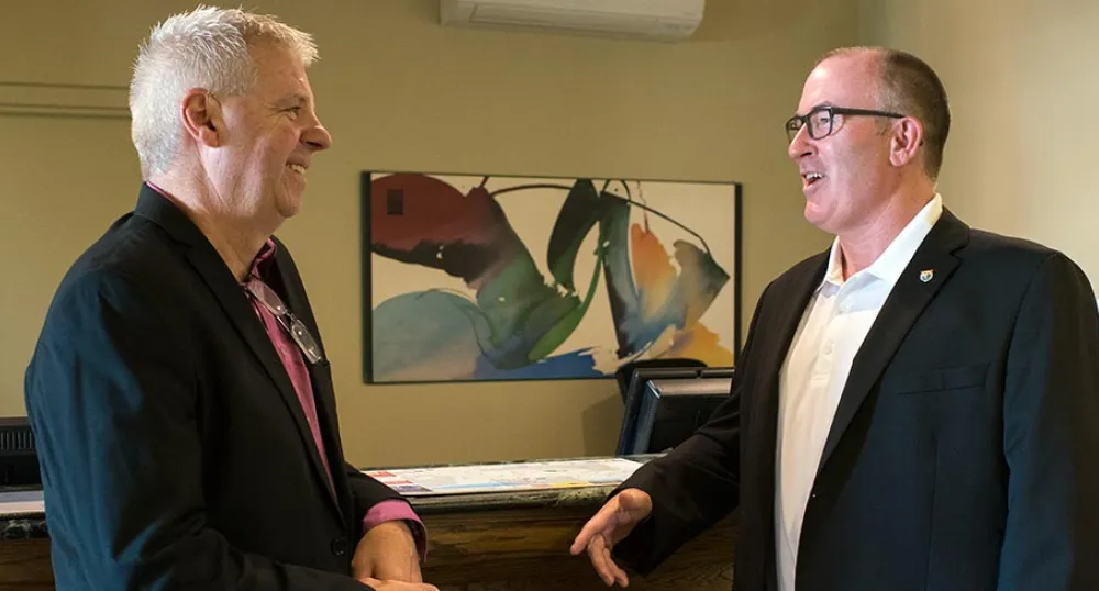 Photo shows two men talking