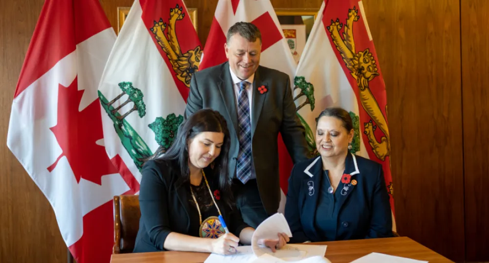 image of people siting at a table signing an agreement