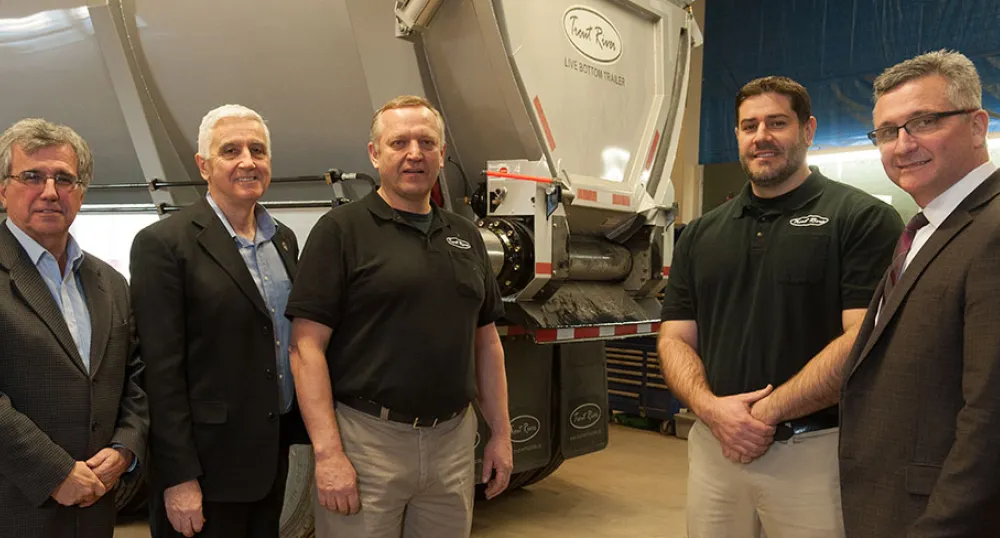 Five men stand in front of a trailer at Trout River industries.