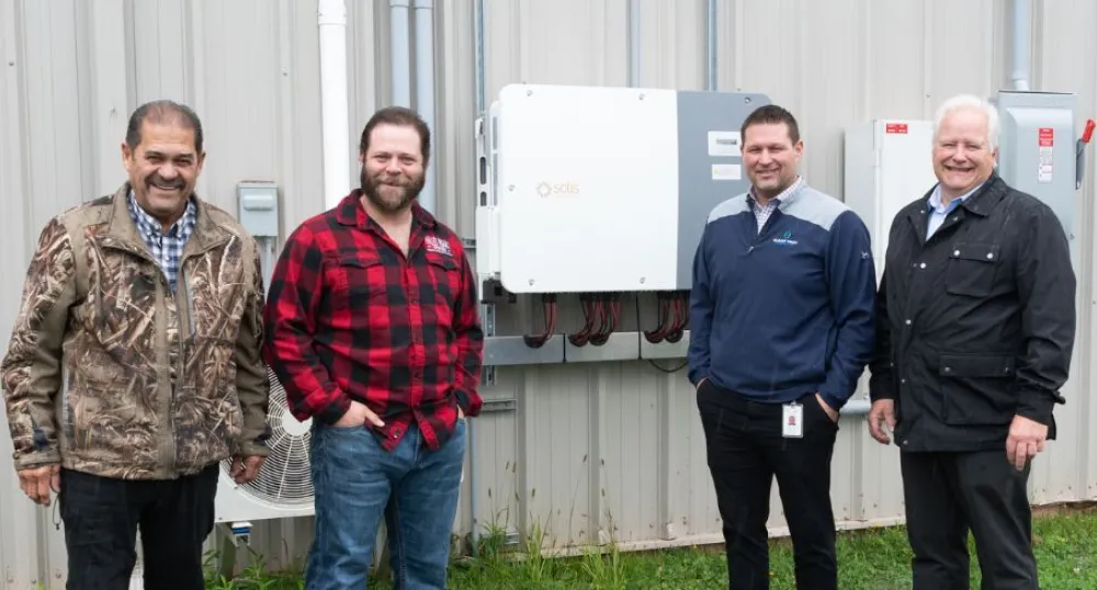 image of four people standing in front of some energy efficiency equipment outside a community rink