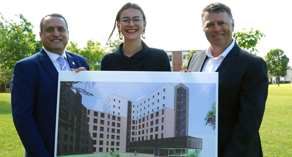 three people holding a picture of a building