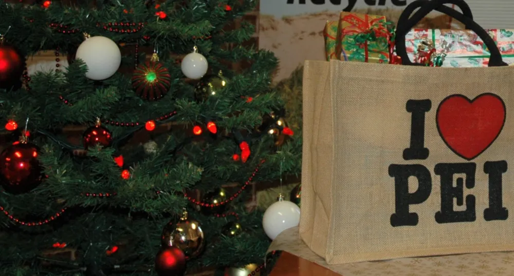 a Christmas tree beside with a shopping bag full of wrapped gifts