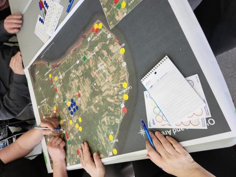 A map laid out on a table with several people around it.