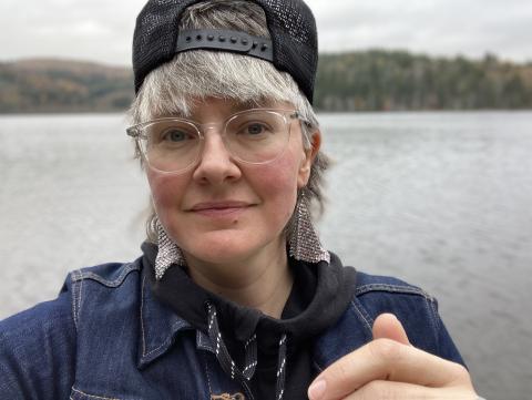 image of a person standing in front of a lake while wearing a hat