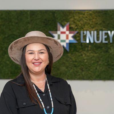 image of a person wearing a wide brim hat standing in front of a sign