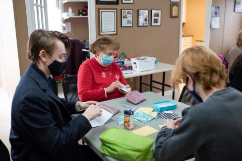 Two boys and a senior writing cards