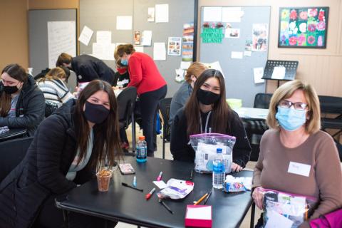 Two girls and a senior sitting at a table