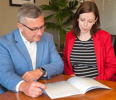 Minister Heath MacDonald and Erin MacGrath-Gaudet review Project ART report at a table