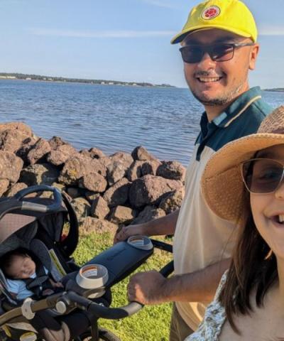 image d'un couple promenant leur poussette et leur bébé le long du front de mer
