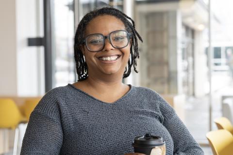 Tamara Steele sourit en tenant une tasse de café.