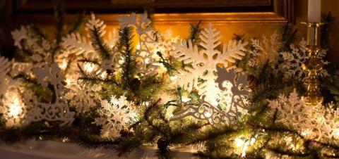 mantle decorated with spruce branches and lights