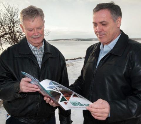 Don Reeves and Minister Robert Mitchell review the new Coastal Property Guide for PEI