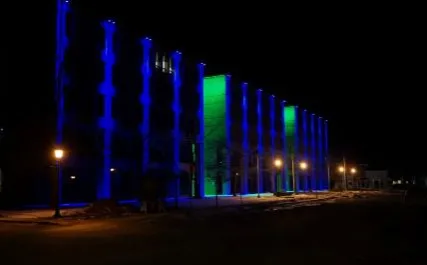 the Shaw building lit up with blue lights at night