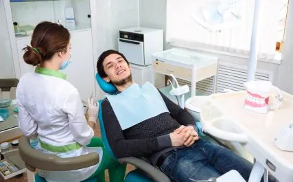 person in a dentist chair talking to a dentist