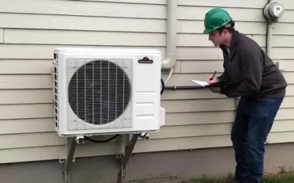 personne regardant une pompe à chaleur à l'extérieur