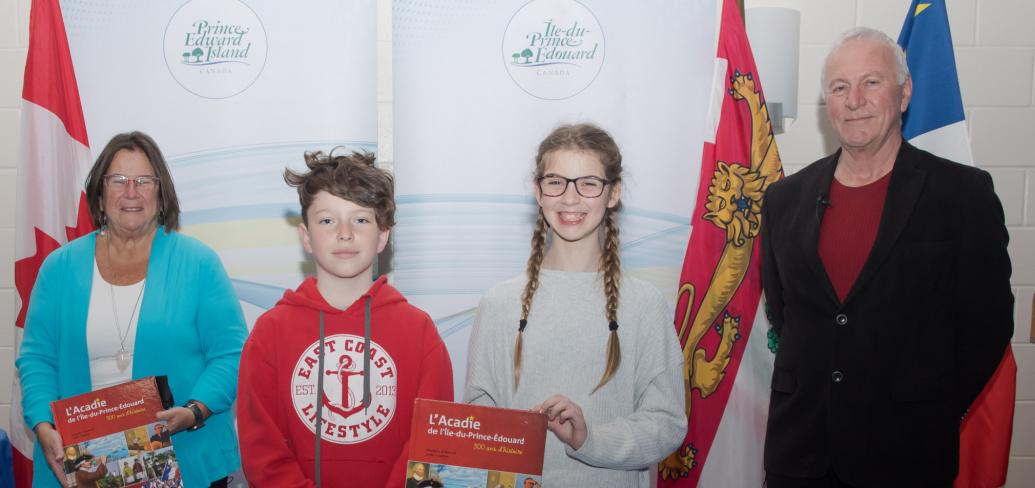 Linda Lowther (left) and Georges Arsenault, co-authors of the book L’Acadie de l Île-du-Prince-Édouard: 300 ans d’histoire, stand with students from École St-Augustin at the book's recent launch 