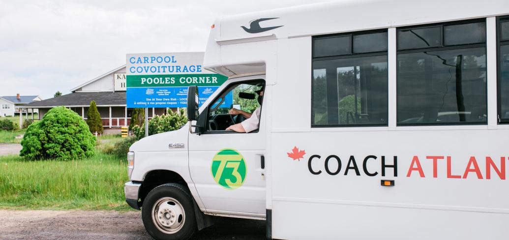 Showing a transit bus parked outside a carpool parking lot in Pooles Corner