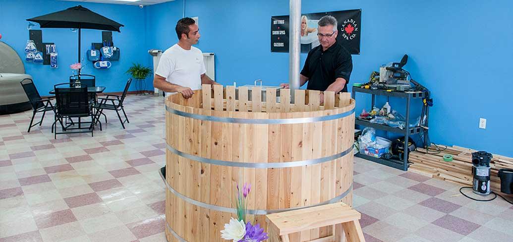 (L to R): Blaine Richards, owner and operator of Richards Total Pool Services shows Minister Heath MacDonald, Economic Development and Tourism an Island-made cedar hot tub. The new cedar tubs are a one-of-a-kind product now available on PEI