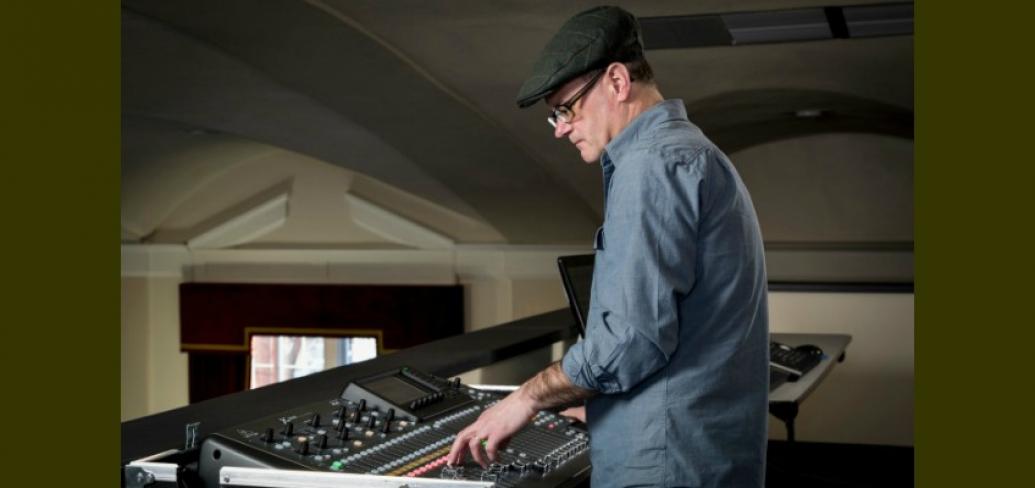 Music composer Craig Dodge is shown in this photo standing at a sound board