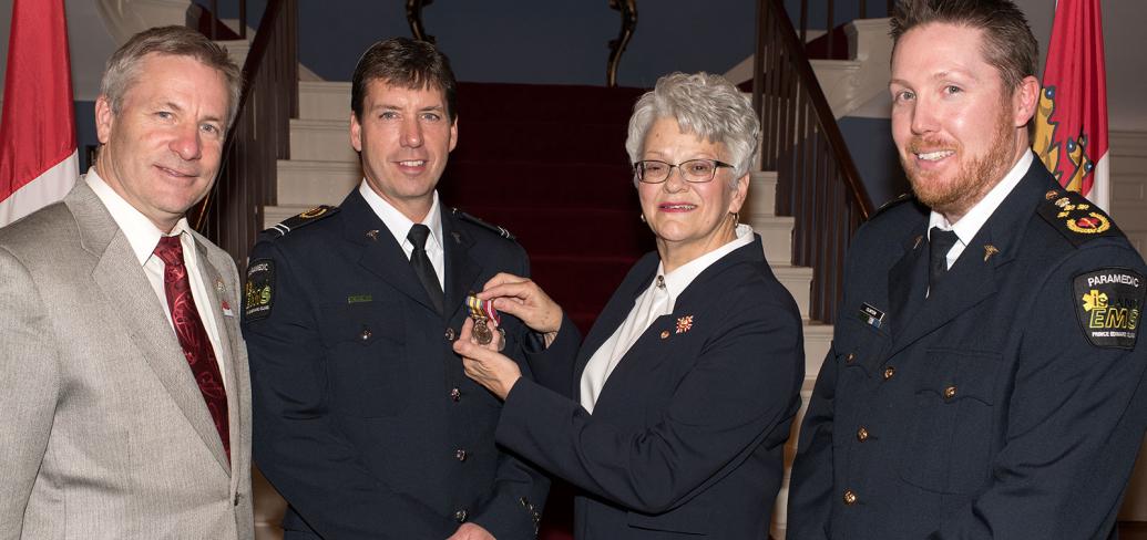 Photo shows Lieutenant Governor Antoinette Perry presenting advanced care paramedic Terrance MacPherson with the award with Minister Robert Henderson and Island EMS general manager Darcy Clinton.  