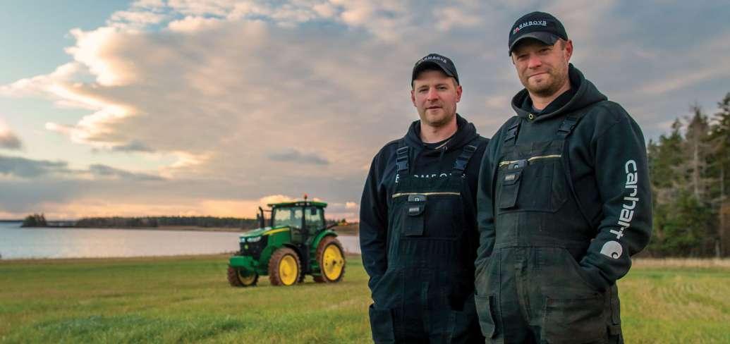 Brothers Bryan and Kyle Maynard of Arlington stand in field with tractor in background