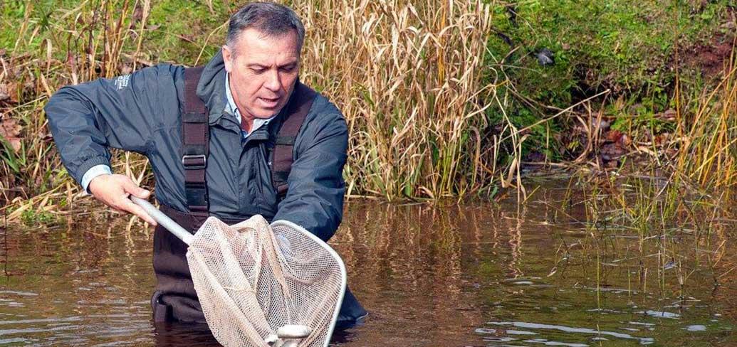 Minister Mitchell releasing fish into a river