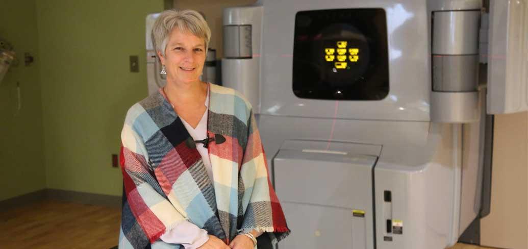 Dawn MacIsaac sits by one of the older Linear Accelerator's at the PEI Cancer Treatment Center