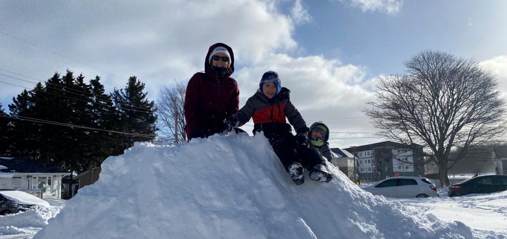 image of three people sitting on top of a snowmound