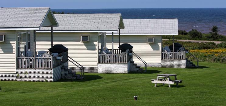 Three white cottages at waterfront in summer