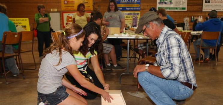 4-H members building a bird house with help from an adult at Rural Youth Fair event