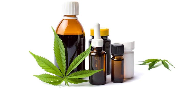 Various cannabis products pictured with a cannabis leaf in the foreground and background