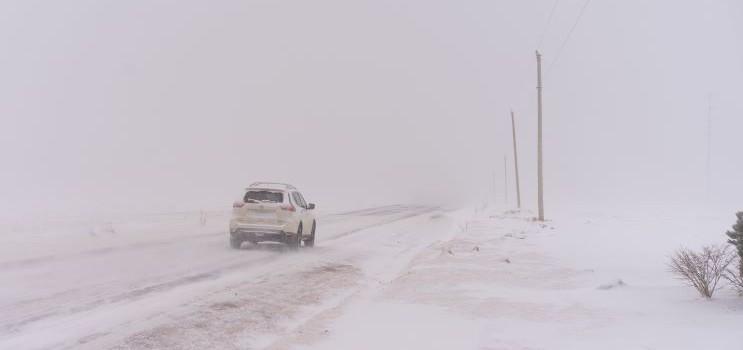 vehicle driving on a snow covered road in the winter