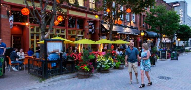 Male and female couple stroll along Victoria Row on a summer evening, PEI