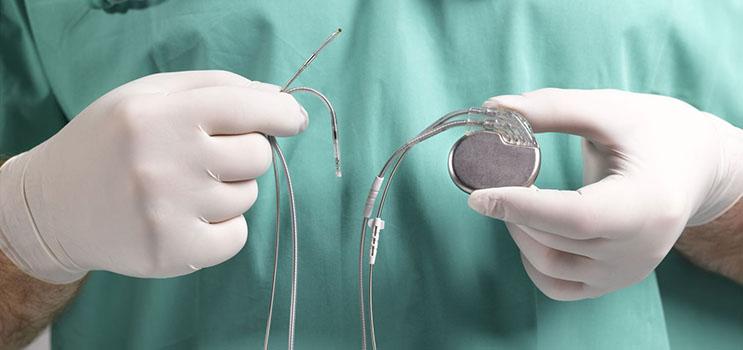 surgeon holding a pacemaker