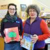 Two librarians holding children's books