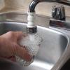 filling a water glass from a kitchen sink faucet
