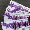 Individuals holds a bunch of bookmarks with purple ribbons