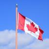 Canadian flag flying against blue sky