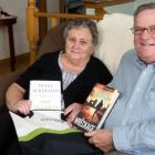 Male and female seniors display books received from home library service