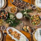 Overhead shot of rustic wooden table set with PEI foods and wine