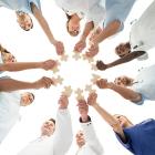 health team standing in a circle with all hands in
