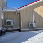 A picture of two outdoor heat pump units in winter