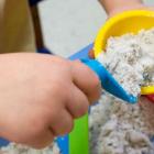 Image of a child's hand playing in a sand table