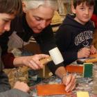 Female demonstrating leather craft to youth