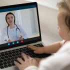 photo of a woman with baby on a couch having a video call on her laptop computer with a doctor