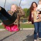 Alyse Rossiter pushes her daugher Akyvia on the swing outside her daycare