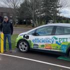 two people standing by the electric charger while charging their car