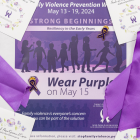 image of a small poster surrounded by purple ribbons and pins
